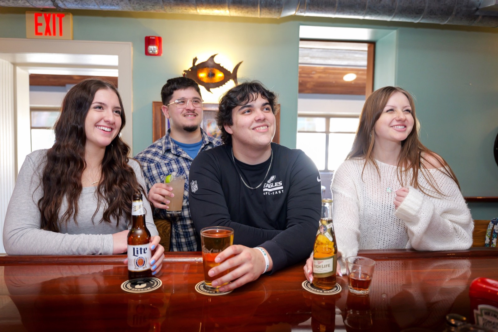 Friends gathered at the bar at Dogtooth Bar and Grill