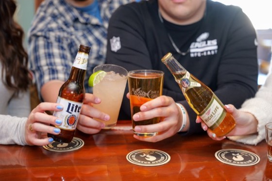 Guests clinking bottles and glasses at the bar