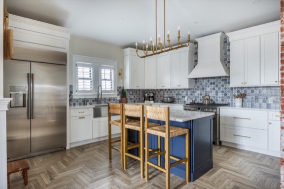 Bright kitchen with herringbone floors and a navy island