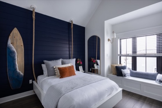 Bedroom with a navy shiplap wall and surfboard headboard