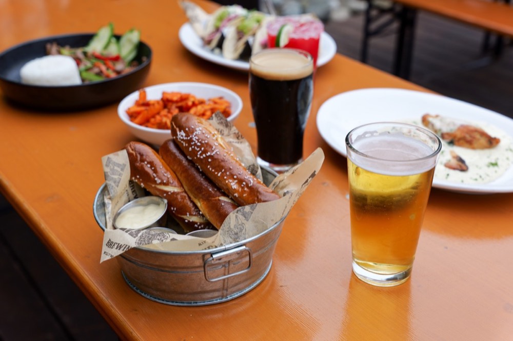 Soft pretzel with beer and a stout on a MudHen table