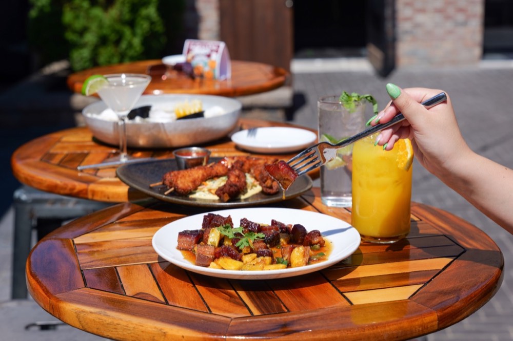 Shared plates and drinks on a biergarten table at MudHen Brewing