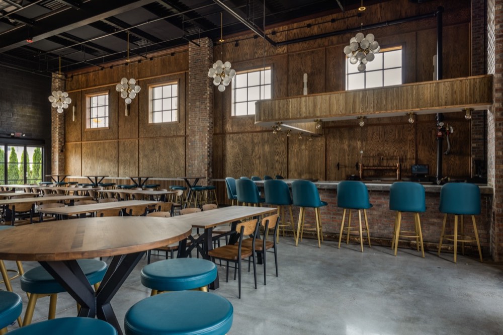 Long communal tables set beneath chandeliers at The Station House